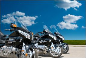 Three street bikes parked next to eachother on the road.