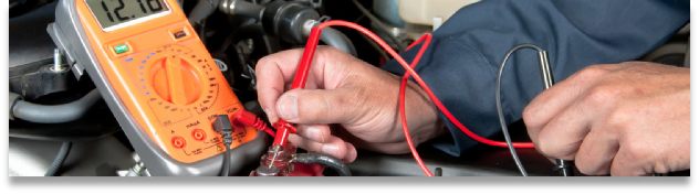 A mechanic from The Bridge Auto works on the engine of a car.